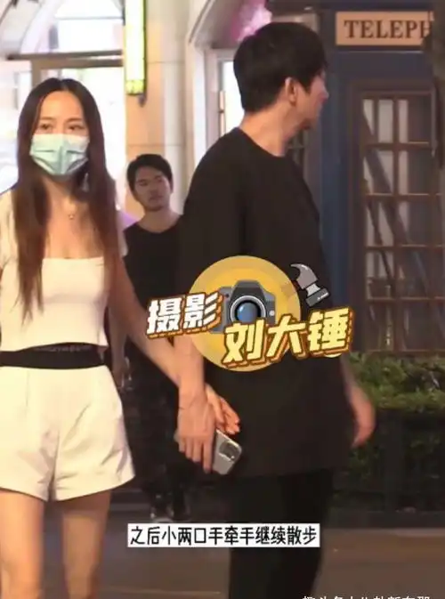48岁大江牵手太太散步,遇路人大方合影,娇妻杨洋清纯似学生
