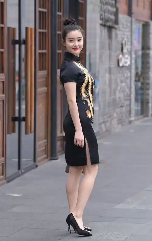 街拍美女身着黑色凤纹开叉旗袍,五官端正复古东方美,端庄大气
